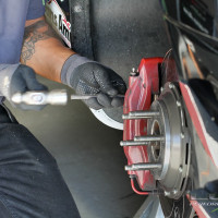 Crew member Robert Montano works on the brakes between sessions (Photo: Chris Clark)